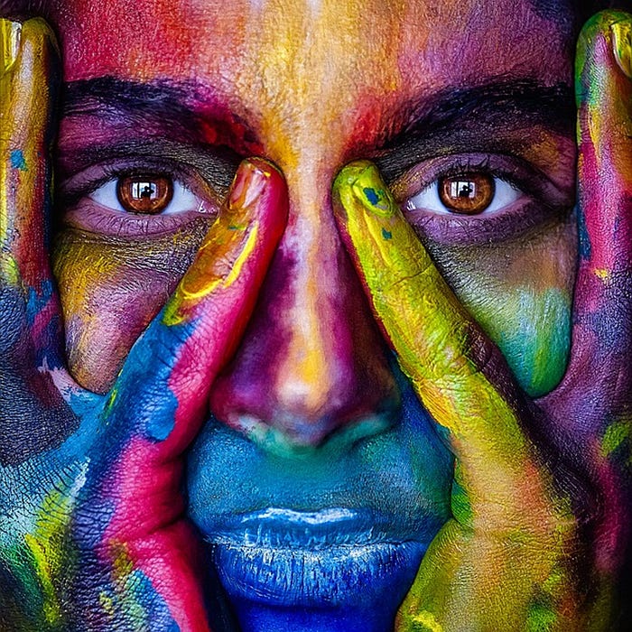 Woman’s face, brown eyes painted in multicolour.